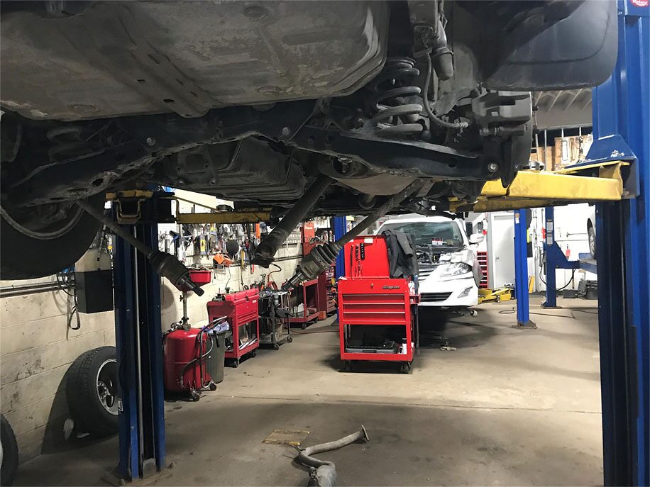 Underside of a vehicle on the hoist during a suspension inspection